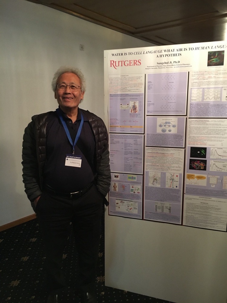 Sungchul Ji at a scientific conference, standing next to his research poster: 'Water is to Cell Language What Air is to Human Language: A Hypothesis'